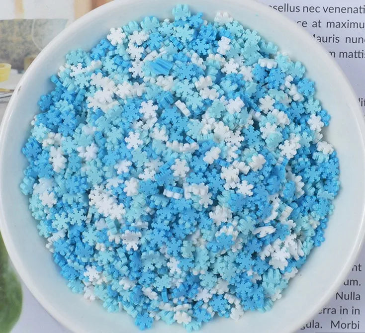 A bowl filled with heart-shaped fake candy sprinkles in blue and white for slime and craft decorations