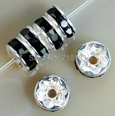 A set of crystal rondelle spacer beads in black and silver are shown with a string for jewelry making.
