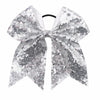 A silver glitter sequin bow for hair, used as a pigtail tie.
