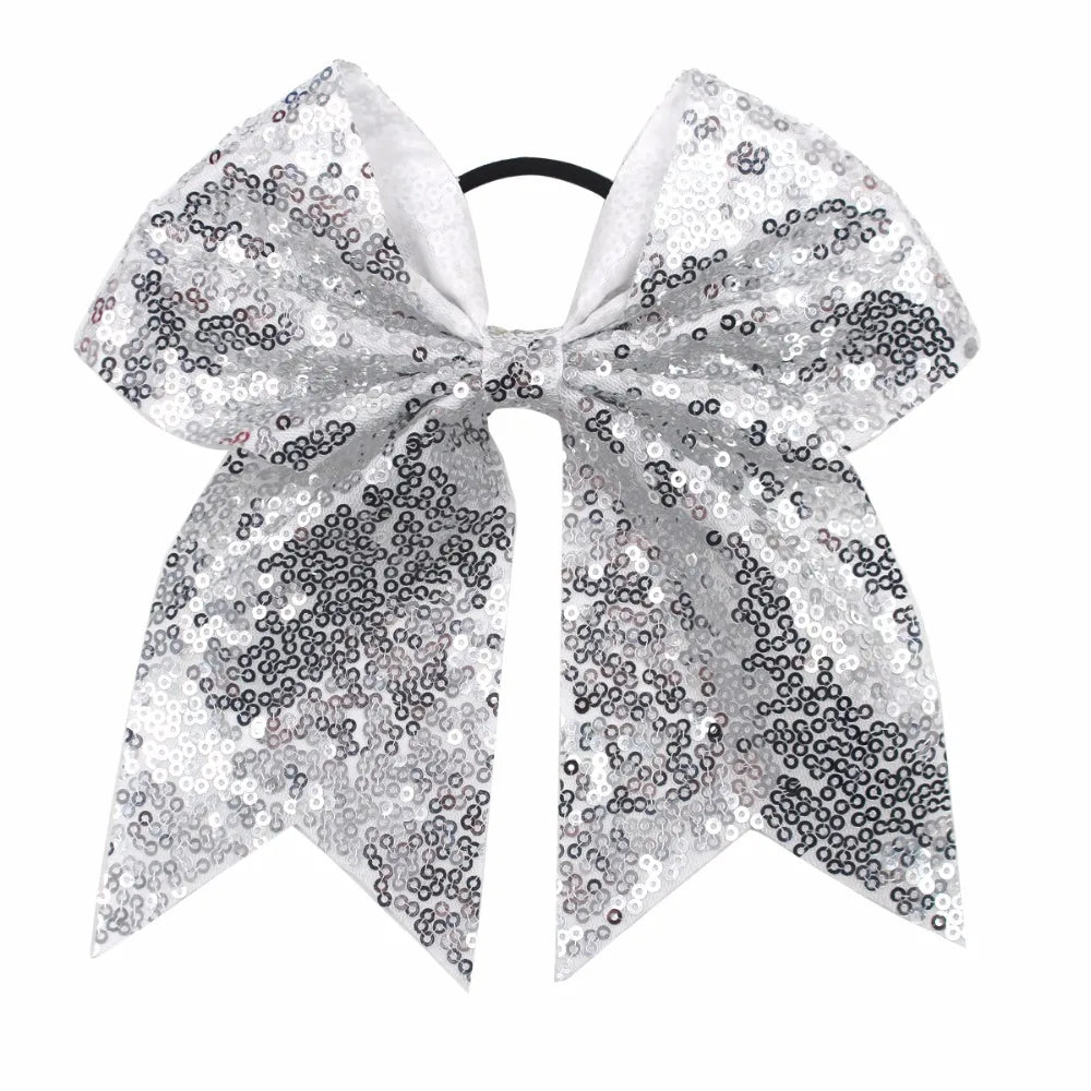 A silver glitter sequin bow for hair, used as a pigtail tie.