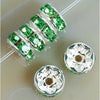 A string of green crystal rondelle spacer beads is shown next to two individual beads on a white background.
