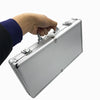 A hand is opening a silver aluminum poker chip carry case with a lock.