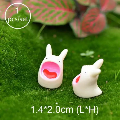 A set of one miniature white animal figurine with a pink interior, displayed on green moss.