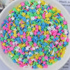 A bowl filled with heart-shaped fake candy sprinkles in various bright colors for slime and craft decorations