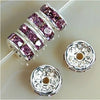 A string of pink crystal rondelle spacer beads threaded onto a silver wire, next to two loose beads.