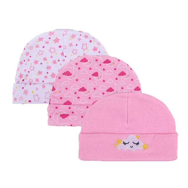 Three pink baby hats featuring different cartoon patterns including stars and clouds