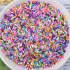 A bowl filled with multicolored heart-shaped fake candy sprinkles for slime and craft decorations