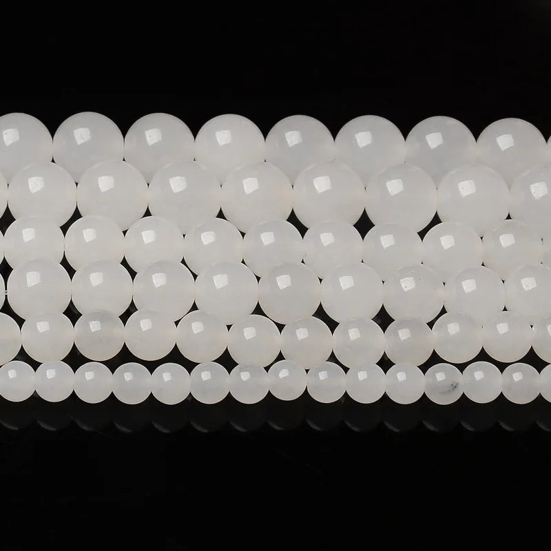 A row of natural white crystal quartz round beads for jewelry making