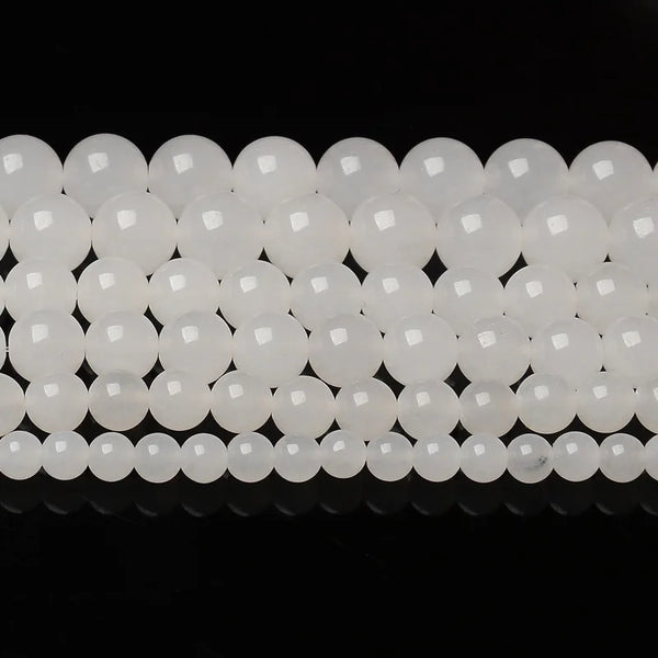 A row of natural white crystal quartz round beads for jewelry making