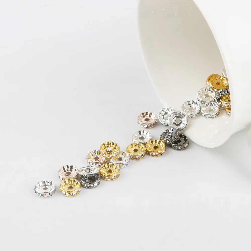 A string of crystal and gold-toned rhinestone spacer beads is displayed on a white surface.