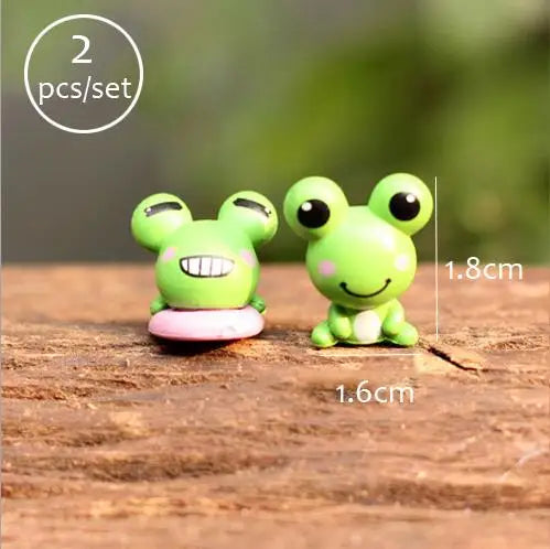 Two bright green miniature animal figurines sitting on a wooden surface.