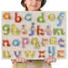 A wooden puzzle set featuring letters and some numbers for toddlers, held by a child.