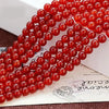 A close-up of strands of natural red carnelian round beads used for jewelry making