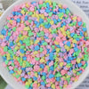 A bowl filled with heart-shaped fake candy sprinkles in various pastel colors like pink, blue, and green.