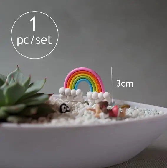 A set of miniature animal figurines shaped like a rainbow is displayed in a white bowl with small white pebbles.