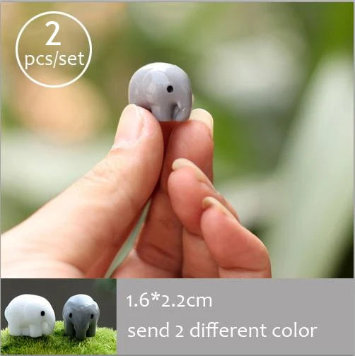 Two gray miniature animal figurines being held by a hand, with dimensions 1.6x2.2cm.