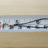 A silver lobster clasp keychain charm is measured against a ruler marked 1 through 7.