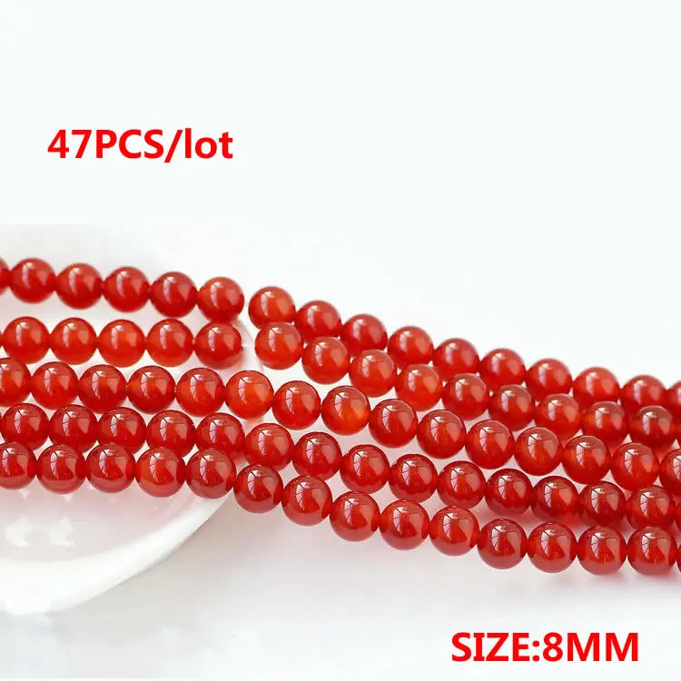 A string of small, round, natural red carnelian beads for jewelry making, with a size of 8mm.