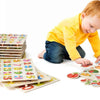 A toddler is interacting with a wooden puzzle set featuring animals, fruits, and shapes.
