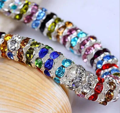 A close-up of a strand of colorful crystal rondelle spacer beads for jewelry making