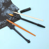 A set of five scratch art tools including a brush, a pencil, and a black applicator, displayed on a light blue background.