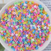 A bowl filled with multicolored heart-shaped fake candy sprinkles for slime and craft decorations