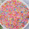 A bowl filled with heart-shaped fake candy sprinkles in various bright colors for slime and craft decorations