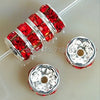 A string of red crystal rondelle spacer beads for jewelry making is shown next to two individual beads.