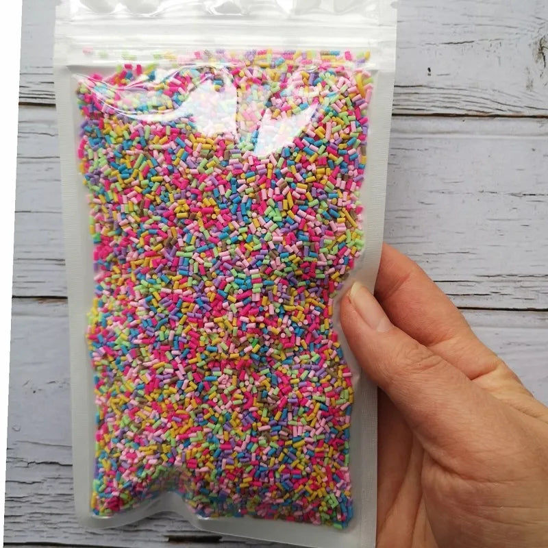 A clear plastic bag filled with heart-shaped pink and green candy sprinkles for slime and craft decorations.