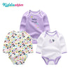 A set of three purple and white cotton baby bodysuits with long sleeves for a baby girl