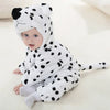A baby wearing an adorable white and black spotted animal hooded romper.