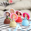 A set of three Transformable Scented Cupcake Princess dolls with pink and white veils displayed on a black grid.