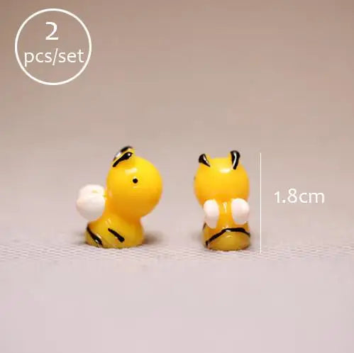 A pair of yellow miniature animal figurines, likely for fairy gardens or terrariums.