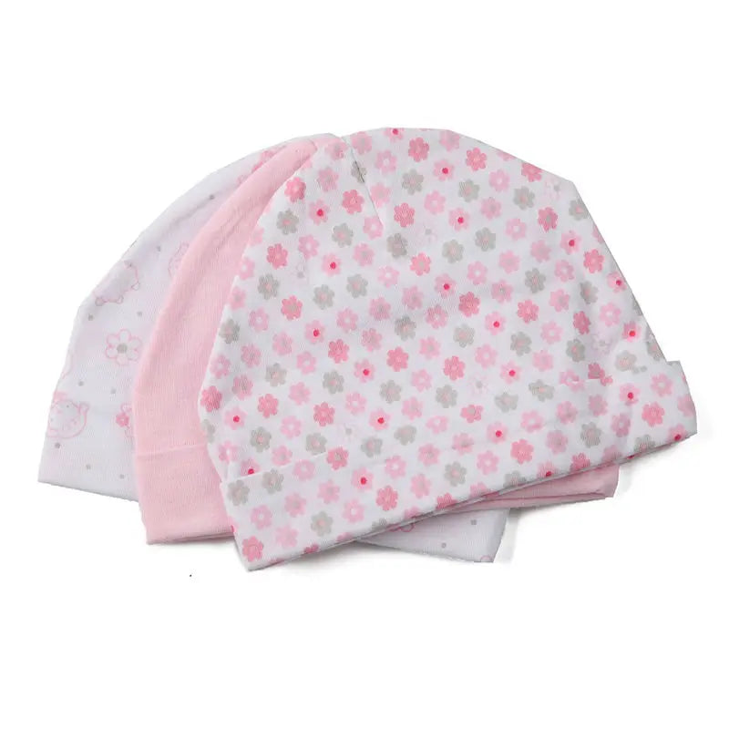 A stack of pink and white baby hats with a floral pattern.
