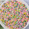 A bowl filled with multicolored heart-shaped fake candy sprinkles for slime and craft decorations