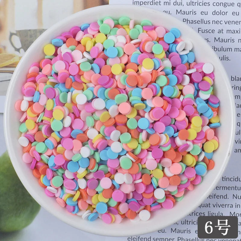 A bowl filled with heart-shaped fake candy sprinkles in various pastel colors like pink, blue, and yellow for crafting.
