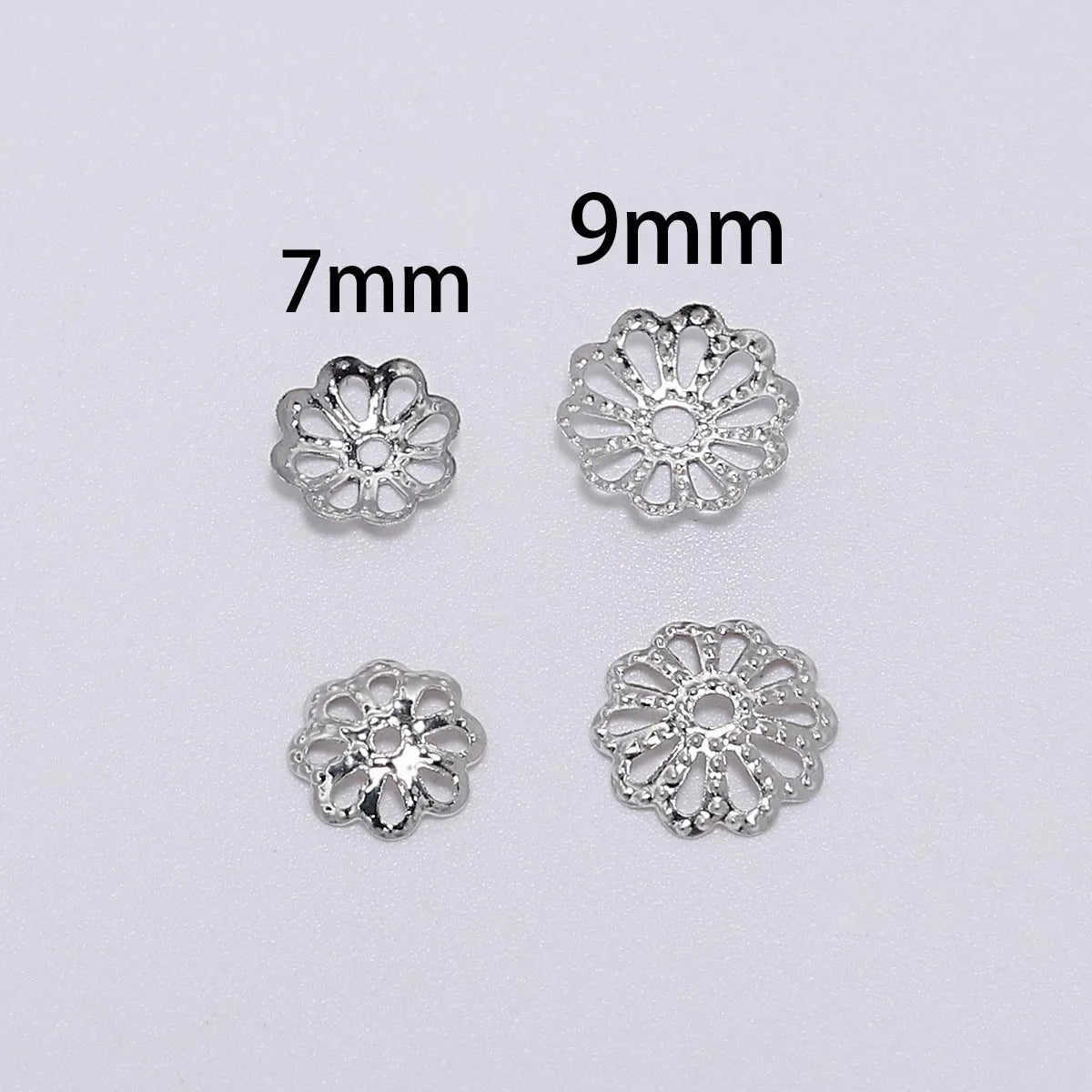 Two silver-toned flower petal bead caps, one 7mm and one 9mm, for jewelry making.