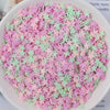 A bowl filled with heart-shaped fake candy sprinkles in pink and green colors for slime and craft decorations