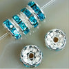 A string of blue crystal rondelle spacer beads threaded onto a clear wire, with loose beads nearby.