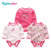 A set of three pink cotton baby bodysuits with long sleeves featuring different patterns and designs.