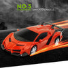 An orange 2-in-1 RC transforming car robot is shown speeding on a dark track with bright light trails.