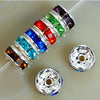 A string of colorful crystal rondelle spacer beads in various gemstone colors, alongside two silver metal findings.