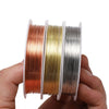 A hand holds a spool of durable copper beading wire for jewelry making in various colors.