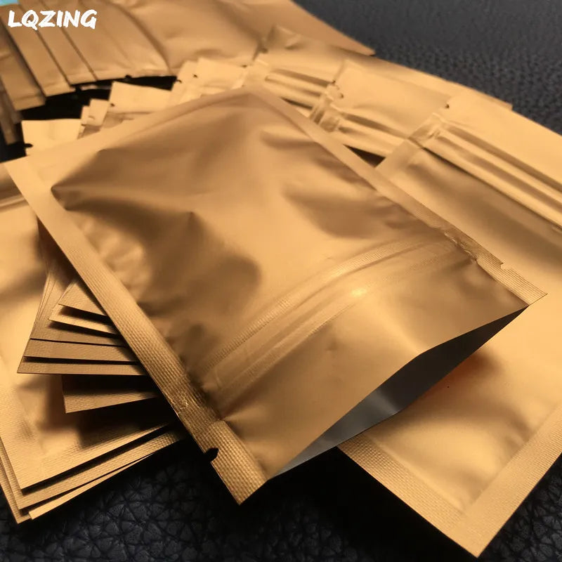 A stack of small, gold-colored reusable ziplock bags are displayed on a dark surface.