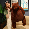 A young woman is posing with an oversized lifelike brown bear plush cushion.