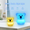 A glowing blue koala night light and a yellow koala night light displayed on a white surface.