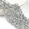Silver faceted crystal glass beads strung together on a white background