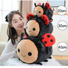 A woman is holding a plush toy of a black bee with red ladybug spots, showing various sizes.