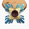 Metal fidget spinner with blue and gold rainbow finish resting on a wooden surface