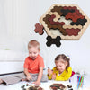 A wooden tangram puzzle board with various colored pieces and a finished puzzle on a table.